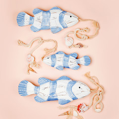 Decorative fish  on a  pastel pink background. Sea concept. Nautical pattern.