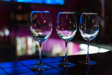 Empty wine glasses in row on bar