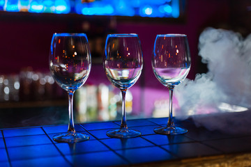 Two empty wine glasses arranged on the counter before the party to start in restaurant or bar with smoke 