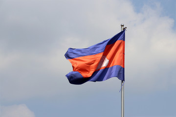 National flag of Cambodia on bright blue sky background. Blown away by wind.