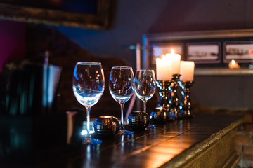 empty wine glasses and candles with illumination lights background. Romantic dinner dating night in bar or restaurant . 