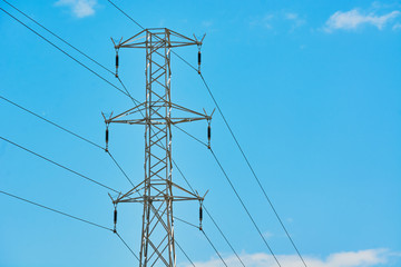 Electric transmission line with steel wires stretched against sky.