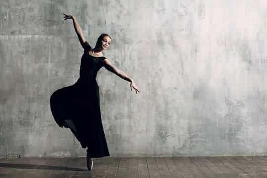 Ballerina female. Young beautiful woman ballet dancer, dressed in professional outfit, pointe shoes and black dress.
