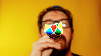 unhappy and depressed man celebrates the carnival or new year, with party horn on a yellow background, footage ideal for representing bad holidays and comic situations