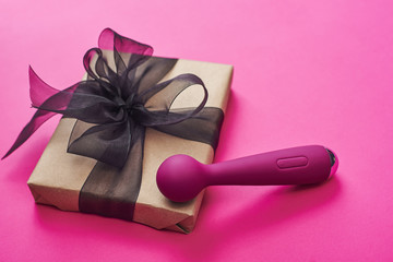 Sex toy gift for the women you love! Close up photo of purple sex toy for her with gift box on a...
