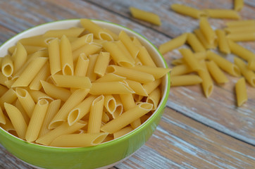 The​ Penne​ Rigate​ raw​ in​ a​ bowl​ on​ the​ table
