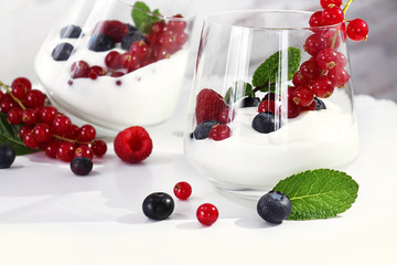 Dessert. Yogurt with fruit, decorated with a leaf of mint. Blueberry, raspberry, red currant. Fresh or organic products from the farm. Selective focus, close-up.