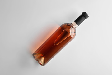 Bottle of tasty wine on light background