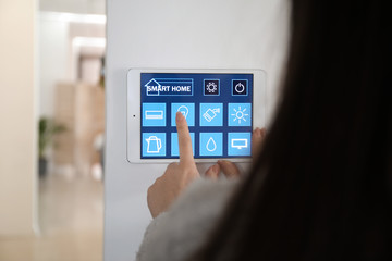 Young woman using application of smart home automation