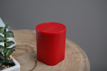 Smart home assistant device on table against grey background