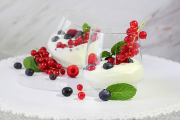 Dessert. Yogurt with fruit, decorated with a leaf of mint. Blueberry, raspberry, red currant. Fresh or organic products from the farm. Selective focus, close-up.