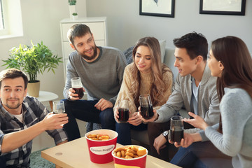 Group of friends eating nuggets and drinking soda at home