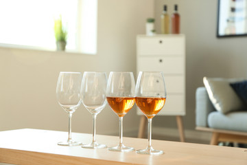 Glasses with tasty wine on table in room