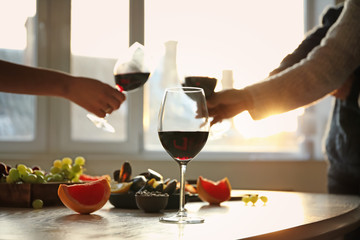 Glass of tasty red wine on table in room