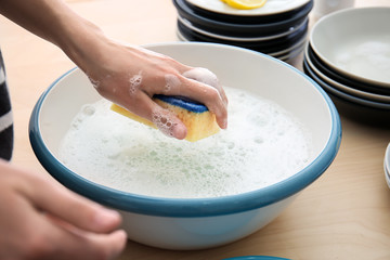Woman washing plate in kitchen