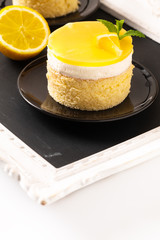 Food concept Homemade Lemon curd sponge cake with fresh whipped cream in black plate with copy space