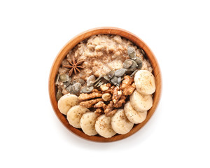 Bowl with tasty oatmeal on white background