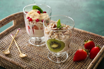 Glasses with tasty oatmeal on wicker tray