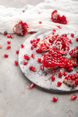 Pieces of ripe pomegranate on grey table