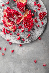 Pieces of ripe pomegranate on grey table