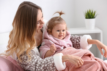 Young woman with her cute little daughter at home