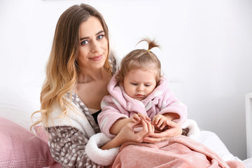 Young woman with her cute little daughter at home
