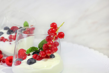 Dessert. Yogurt with fruit, decorated with a leaf of mint. Blueberry, raspberry, red currant. Fresh or organic products from the farm. Selective focus, close-up.