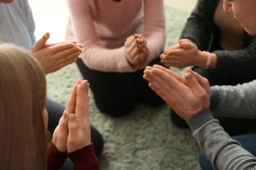Group of people praying together indoors