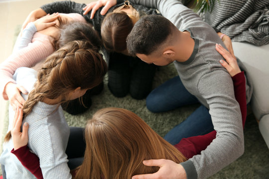 Group of people praying together indoors