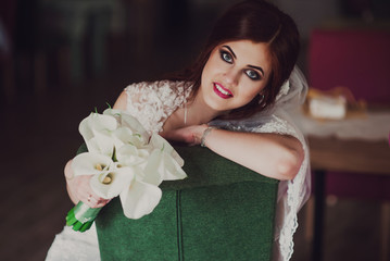 Bride holding flowers in hands, young beautiful bride in white dress holding wedding bouquet