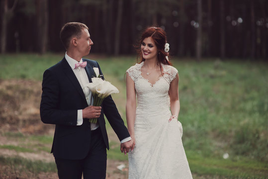 Bride and groom are walking in the woods