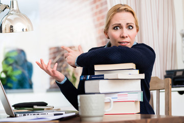 Worried woman with stack of books