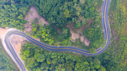 Aerial top view of a road in the forest