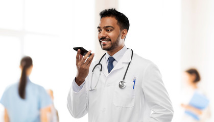 medicine, technology and healthcare concept - smiling indian male doctor in white coat with...