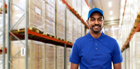 logistic business, shipment and people concept - happy indian delivery man or warehouse worker in...