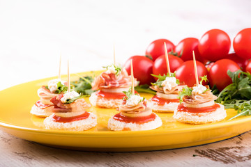 Delicious canapes with bacon and tomato