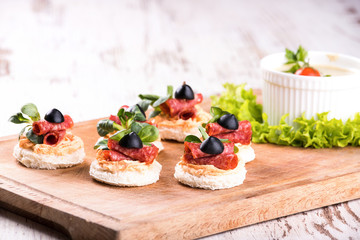 Delicious canapes with salami and spices