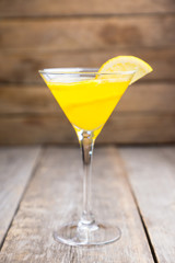 Fresh lemon cocktail in martini glass on the wooden background. Selective focus. Shallow depth of field.
