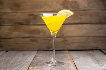 Fresh lemon cocktail in martini glass on the wooden background. Selective focus. Shallow depth of field.
