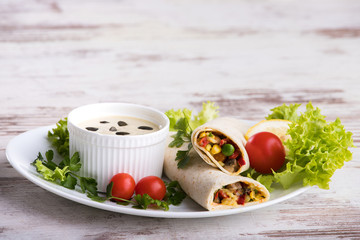 Homemade delicious burritos with vegetables and sauce