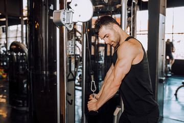 Closeup of a muscular young man lifting weights