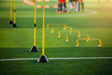 yellow hurdles and ladder drills on green artificial turf