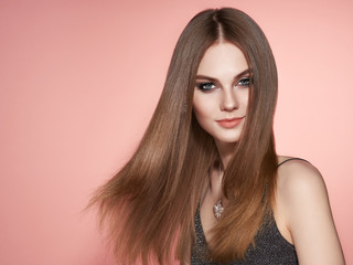 Naklejka premium Brown-haired Girl with Long Healthy and Shiny Smooth Hair. Care and Beauty. Beautiful Model Woman Smiling. Make-Up and Jewelry