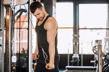 Fototapeta na wymiar Determined muscular man working out in gym
