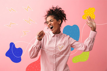 Beautiful young african woman posing isolated over pink wall background screaming singing.