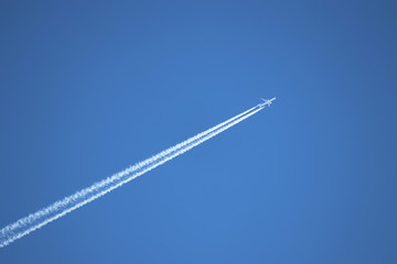 Jet airplane with contrail. Trace of the high flying plane in the clear blue sky