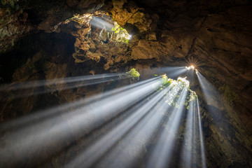 Sun shining through the rocky ceiling in Buddha cave, Marble Mountains, Vietnam