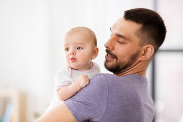 family, parenthood and people concept - father with little baby girl at home