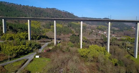 FLYING UNDER THE TRAIN BRIDGE IN A GREEN VALLEY