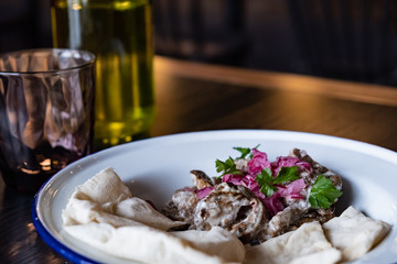 Egg-plant salad with pita served in a restaurant. Close-up view of vegan aubergine dish, shot in natural light